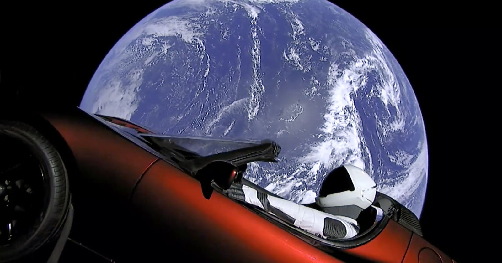 Image: Tesla's red car in outer space, floating past Earth with Rocketman at the wheel