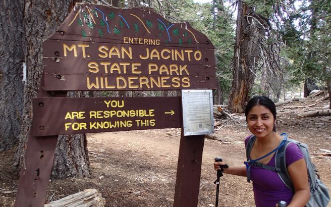 Woman standing at a sign for Mt. San Jacinto State Park Wilderness.