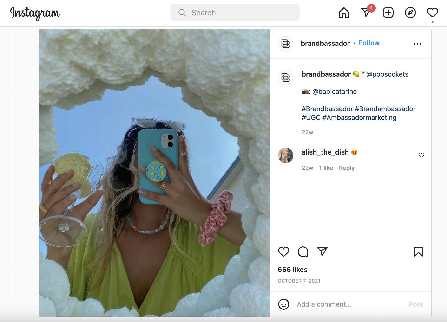 A screenshot Popsockets’ Emoji Outfit Challenge Instagram post. The image features a woman holding a phone with a lemon Popsockets design, corresponding to the lemon emoji.